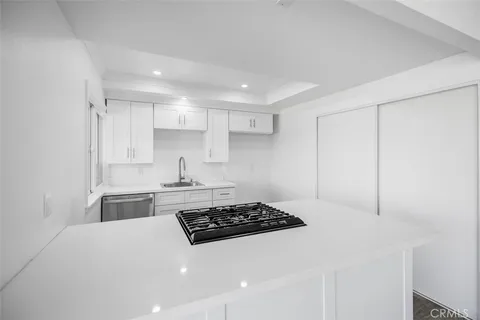 a kitchen with a stove and white cabinets