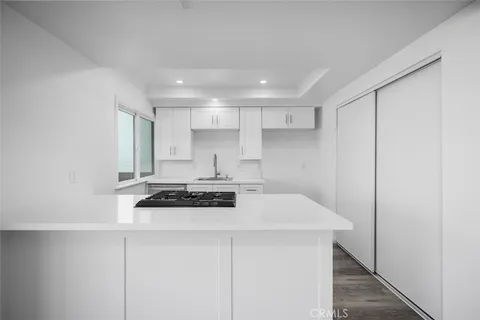 a kitchen with stainless steel appliances a stove a sink and white cabinets