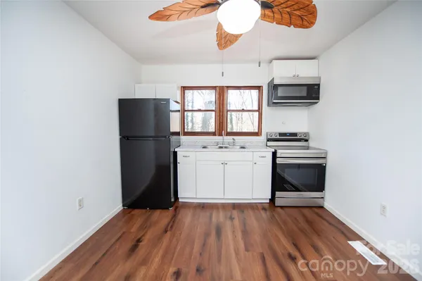 a kitchen with a refrigerator and a stove top oven