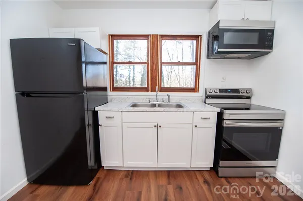 a kitchen with a refrigerator stove and white cabinets