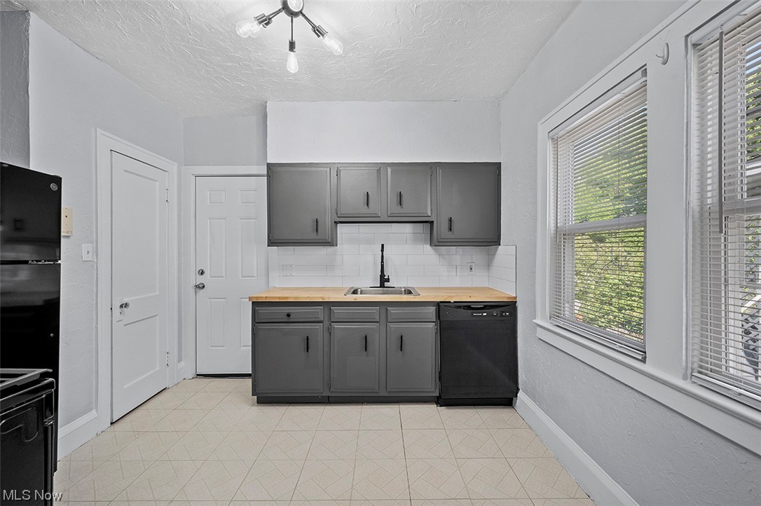 2174 Oakdale Road Cleveland, OH 44118 - Photo 10 of 35 Kitchen with sink, light tile floors, gray cabinets, dishwasher, and tasteful backsplash