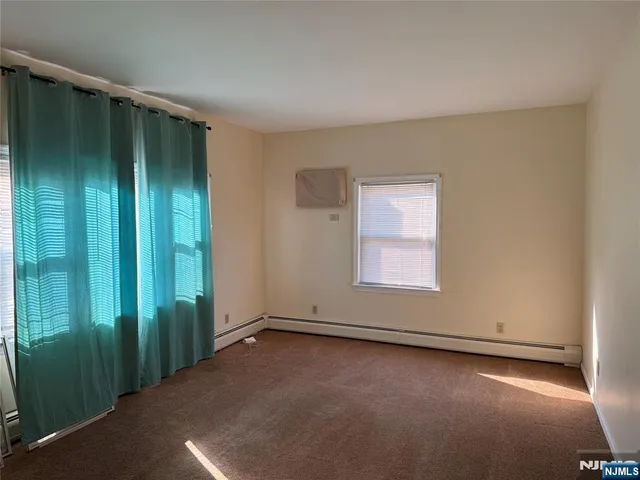 an empty room with window and closet area