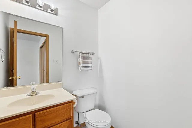 a bathroom with a sink vanity mirror and toilet