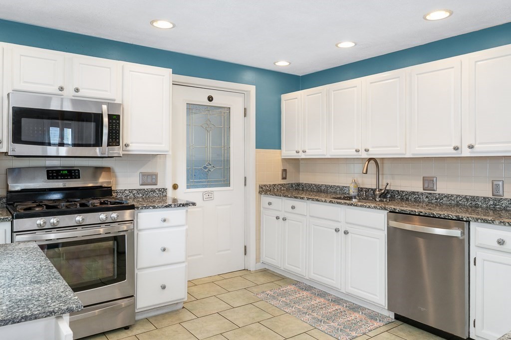 9 Alpine Court Gloucester, MA 01930 - Photo 12 of 32 a kitchen with granite countertop white cabinets sink and stainless steel appliances
