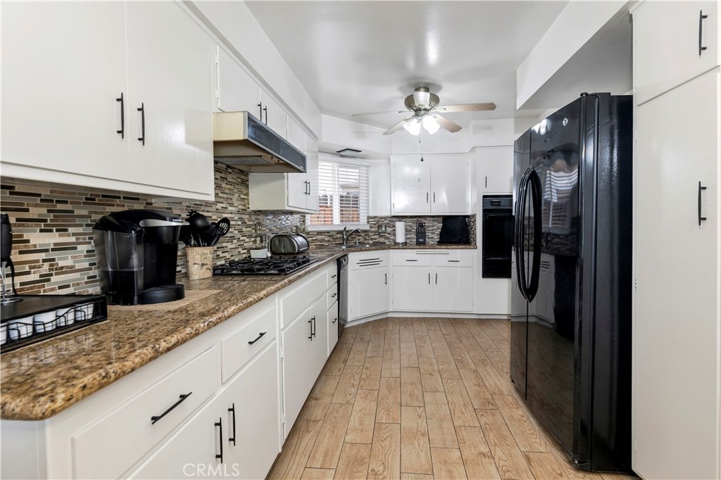 10409 Pendleton Street Riverside, CA 92505 - Photo 15 of 35 a kitchen with stainless steel appliances granite countertop a refrigerator a sink dishwasher a stove and a microwave oven on the kitchen