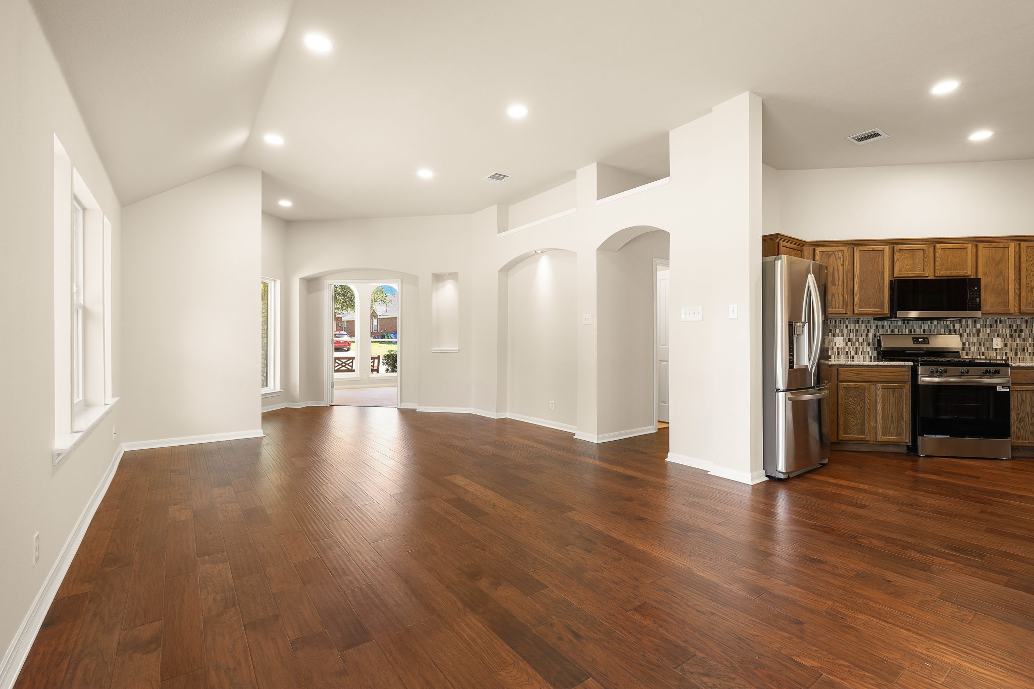 1100 Springbrook Road Pflugerville, TX 78660 - Photo 9 of 23 Rich hardwood flooring flows through this luminous interior with architectural archways.