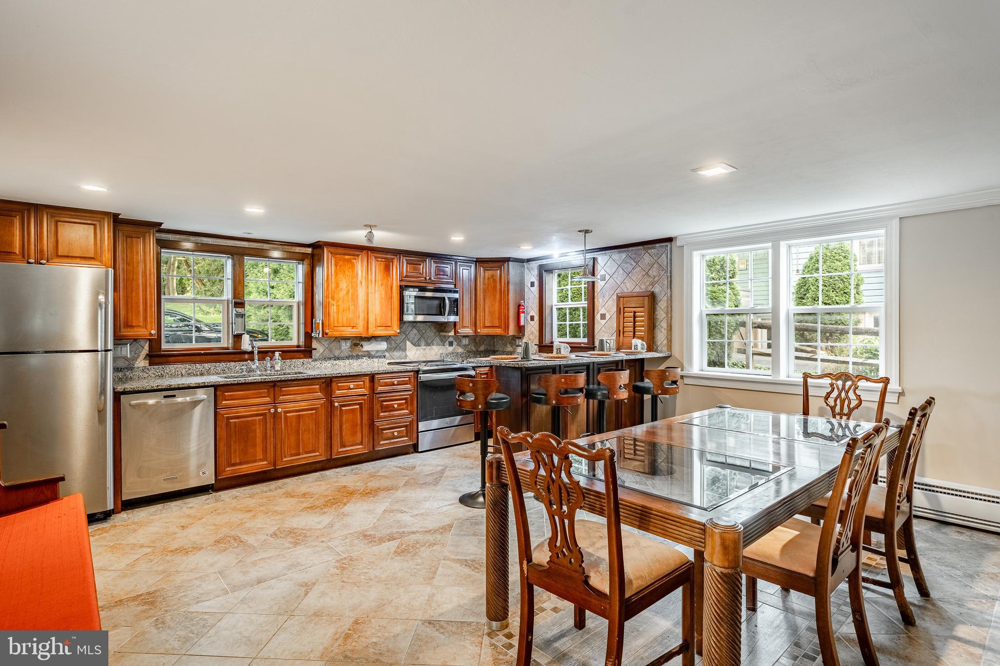 59 East Main Street Elverson, PA 19520 - Photo 11 of 43 a kitchen with stainless steel appliances granite countertop a stove a sink a refrigerator dining table and chairs
