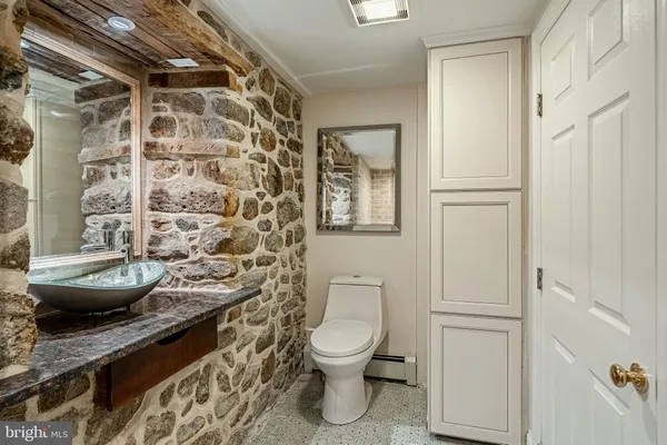 a bathroom with a granite countertop toilet a sink and a shower
