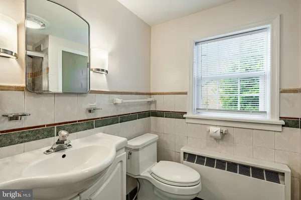 a bathroom with a sink a toilet and a mirror