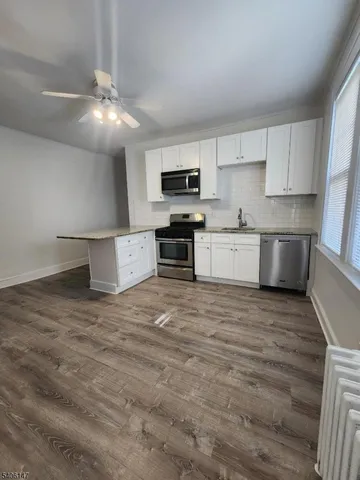a open kitchen with stainless steel appliances granite countertop a stove and a sink