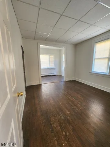 an empty room with wooden floor and entrance