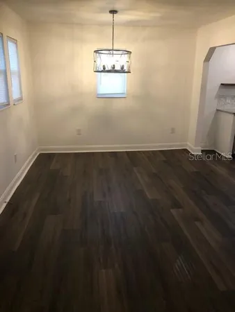 a kitchen with granite countertop a sink cabinets and wooden floor