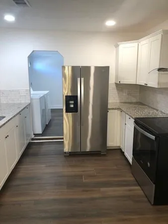 a kitchen with a refrigerator and a stove top oven