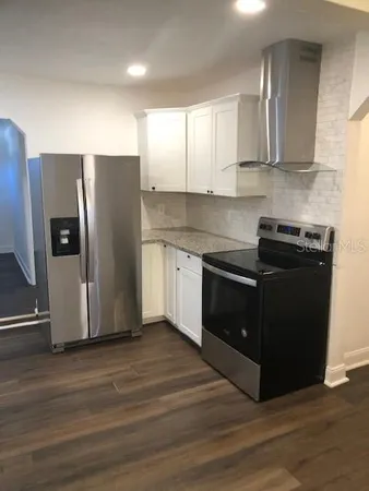 a view of an empty room with wooden floor