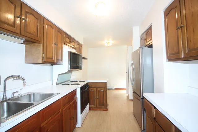 a kitchen with stainless steel appliances a sink cabinets and a counter top space