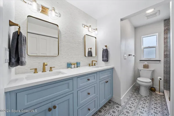 a bathroom with a toilet a sink a vanity a mirror and vanity