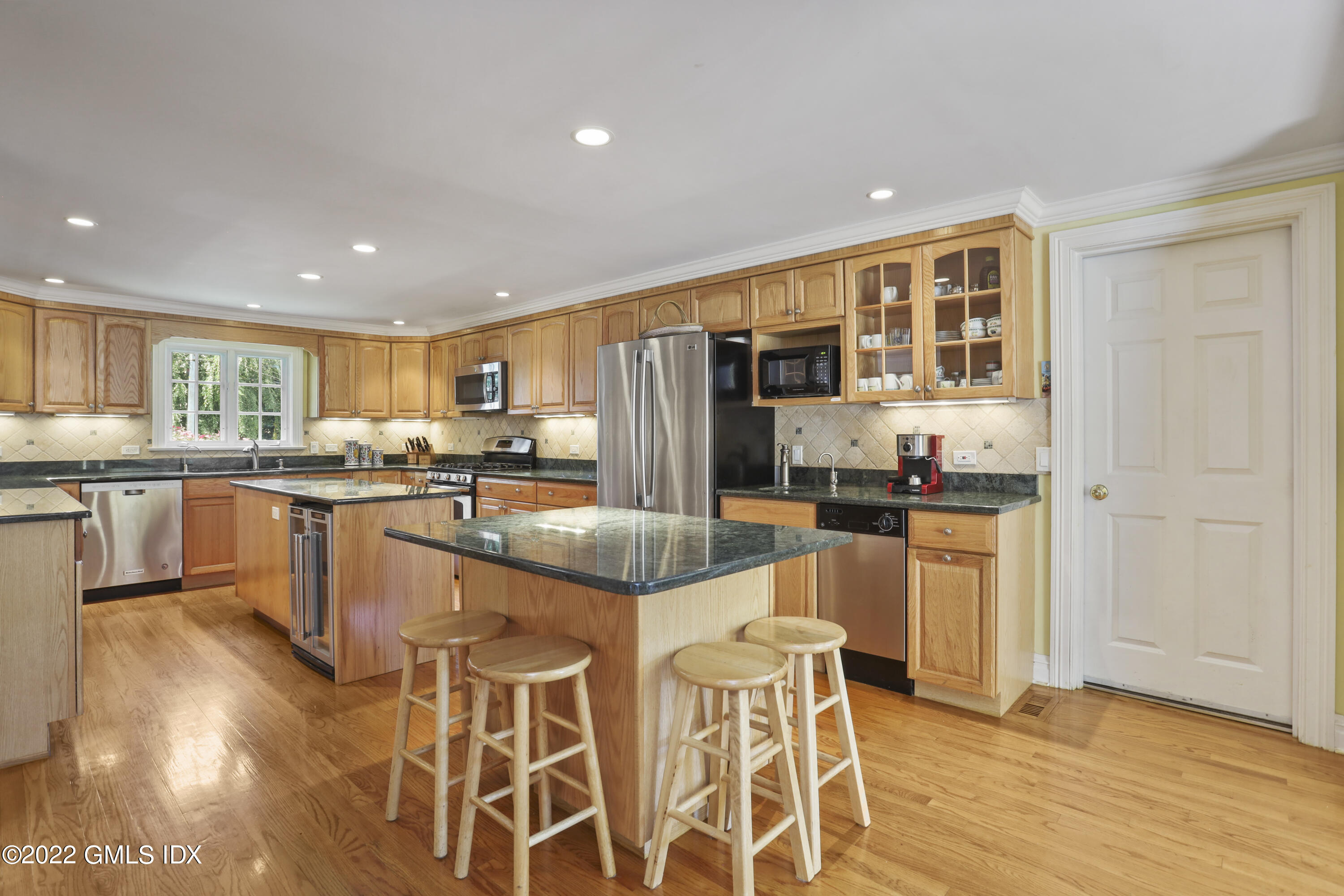 90 Carter Drive Stamford, CT 06902 - Photo 19 of 40 a kitchen with stainless steel appliances granite countertop a stove top oven a sink a dining table and chairs