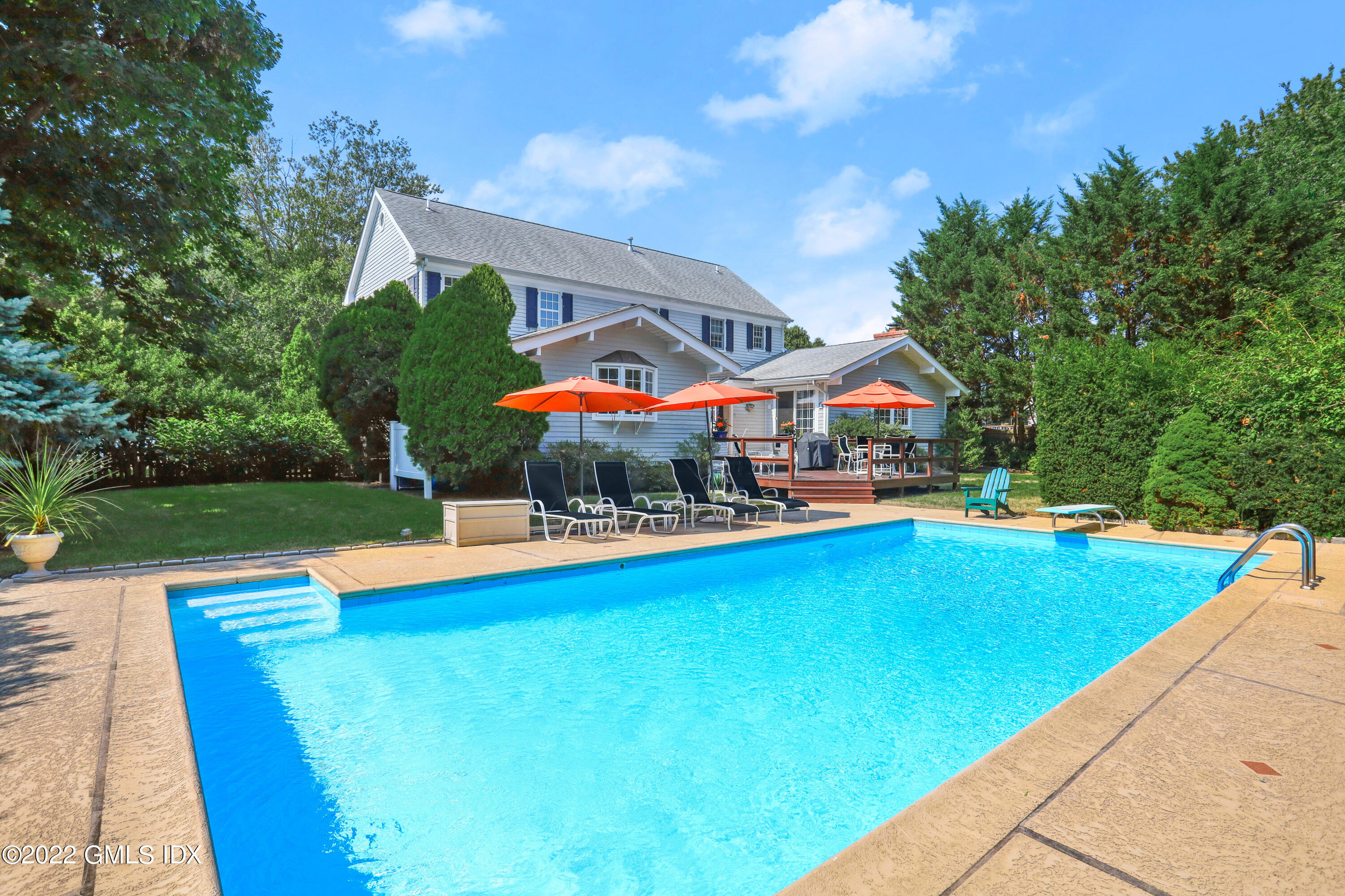 90 Carter Drive Stamford, CT 06902 - Photo 4 of 40 a view of a swimming pool with lawn chairs and plants