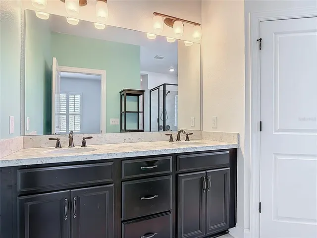 a bathroom with a double vanity sink and a mirror
