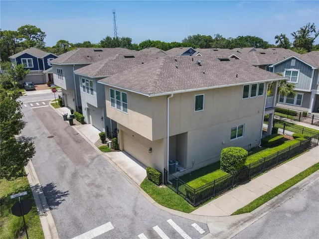 an aerial view of a house with a yard and greenery