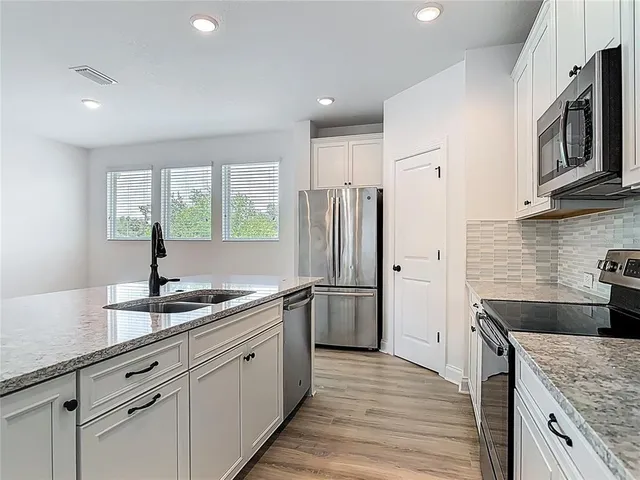 a kitchen with a sink stove and refrigerator
