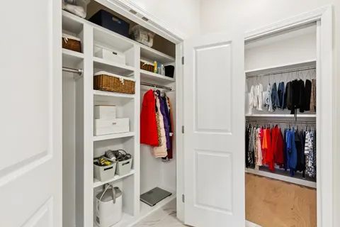 a view of walk in closet with clothes and shoes