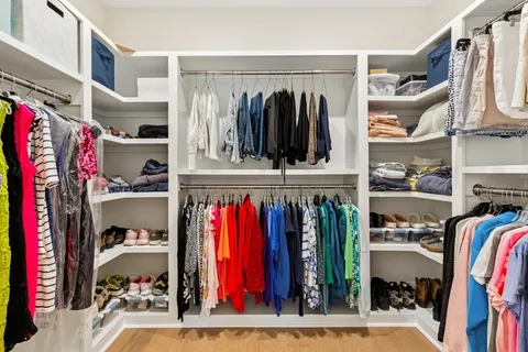 a view of walk in closet with clothes and shoes