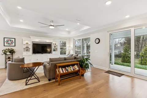 a living room with furniture a flat screen tv and a floor to ceiling window