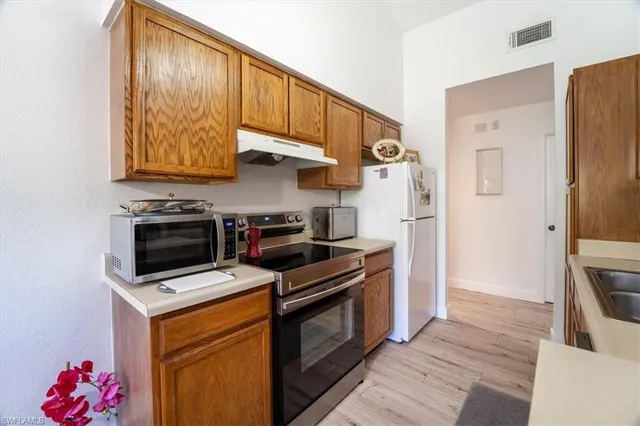 a kitchen with stainless steel appliances granite countertop a stove a refrigerator and a microwave