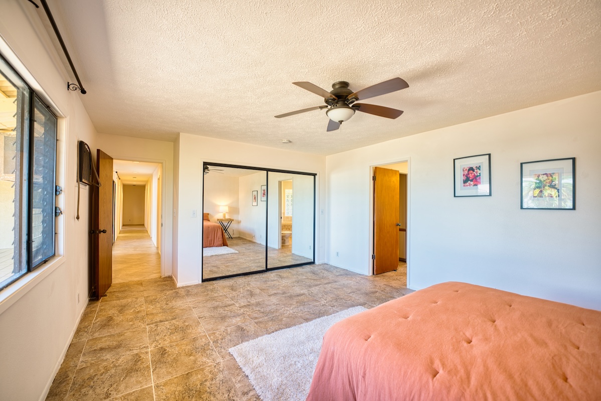 708 Kukuau Street Hilo, HI 96720 - Photo 14 of 18 a bedroom with a large bed and a chandelier