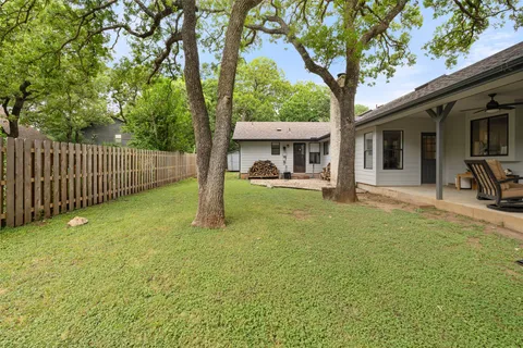 a view of a house with backyard and a tree
