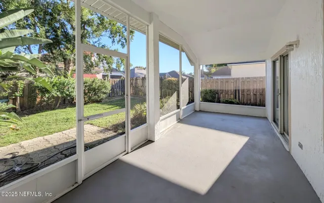 a view of a room with a large window and wooden floor