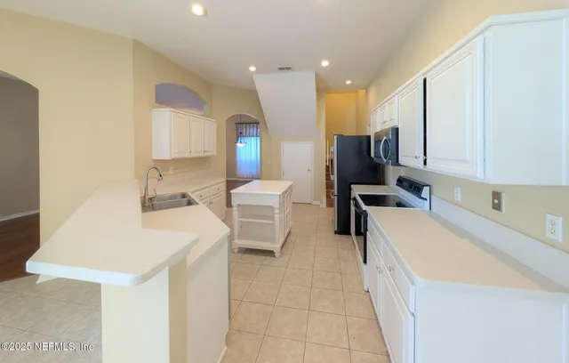 a kitchen with a sink a table and chairs