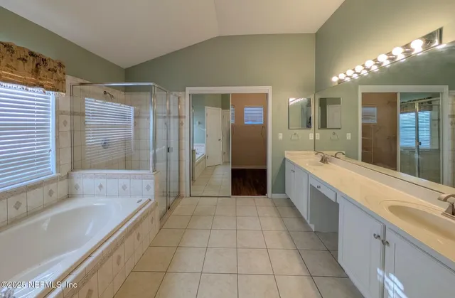 a large bathroom with a tub a sink a mirror and a shower