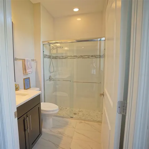 a bathroom with a granite countertop sink a toilet and shower