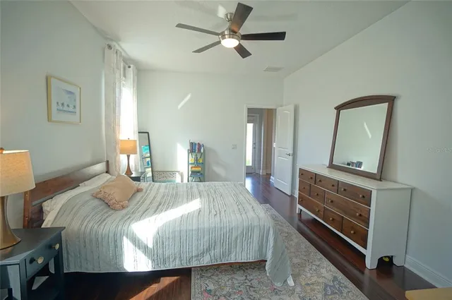 a bedroom with a bed and a mirror on the dresser