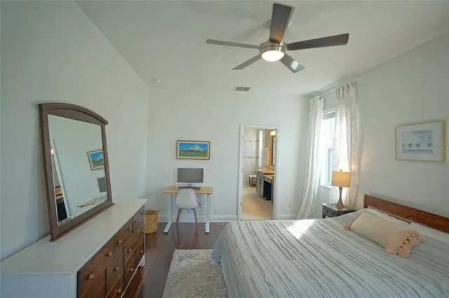 a view of a livingroom with wooden floor and a ceiling fan