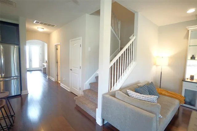 a view of a livingroom with wooden floor and staircase