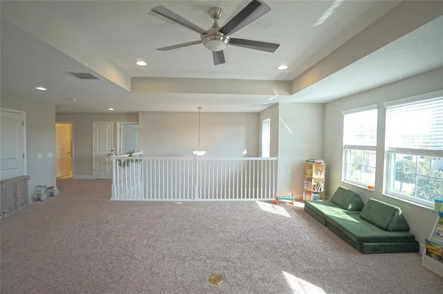 a view of a livingroom with a ceiling fan and windows
