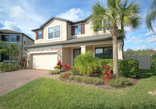 a front view of a house with a yard and potted plants