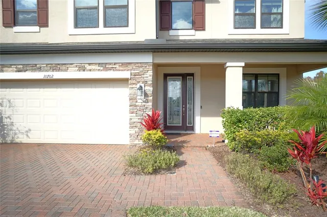 a front view of a house with a yard and trees