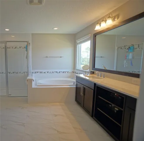 a spacious bathroom with a tub sink and mirror