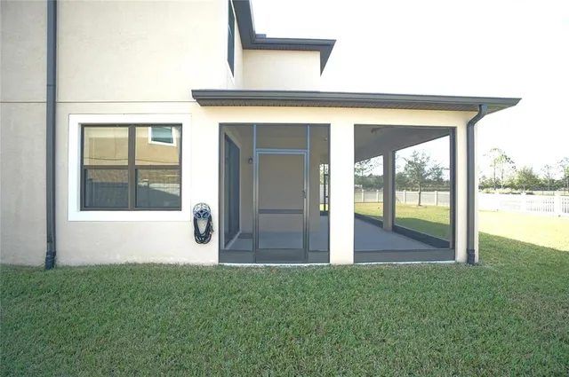 a view of an house with backyard and trees