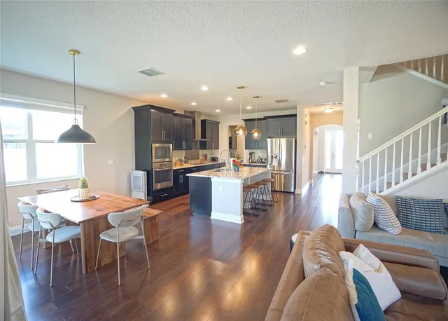 a open kitchen with stainless steel appliances kitchen island granite countertop a table and chairs