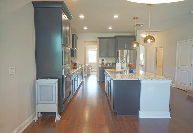 a view of a kitchen and kitchen island with a sink