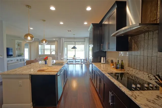 a kitchen with granite countertop a sink stove and cabinets