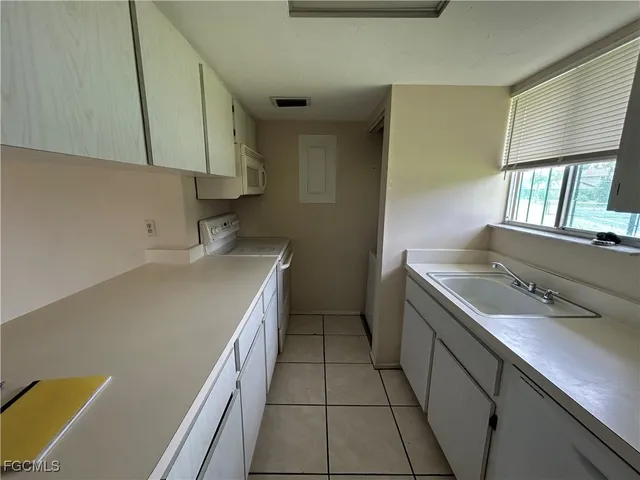 a kitchen with a sink a stove and cabinets