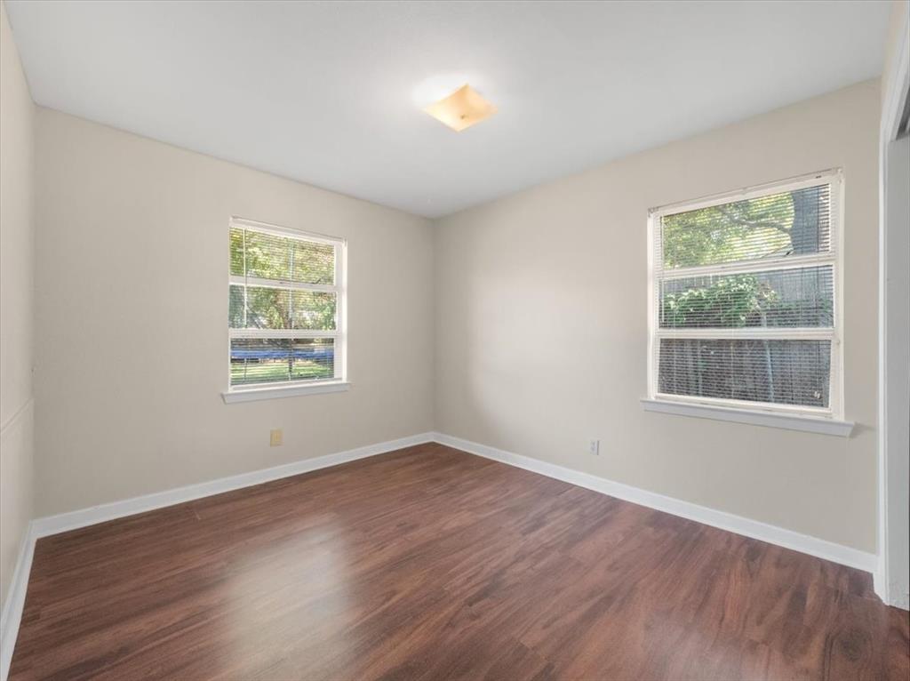 403 Rolando Drive Garland, TX 75040 - Photo 13 of 25 a view of an empty room with wooden floor and a window