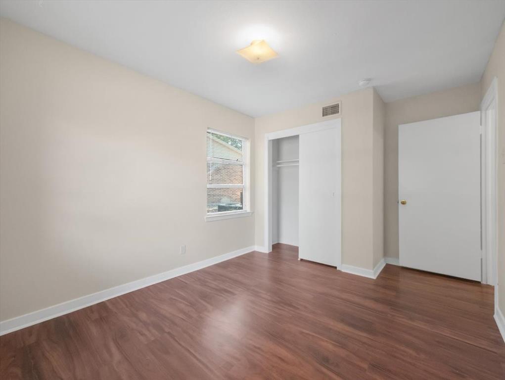 403 Rolando Drive Garland, TX 75040 - Photo 14 of 25 a view of an empty room with wooden floor and a window