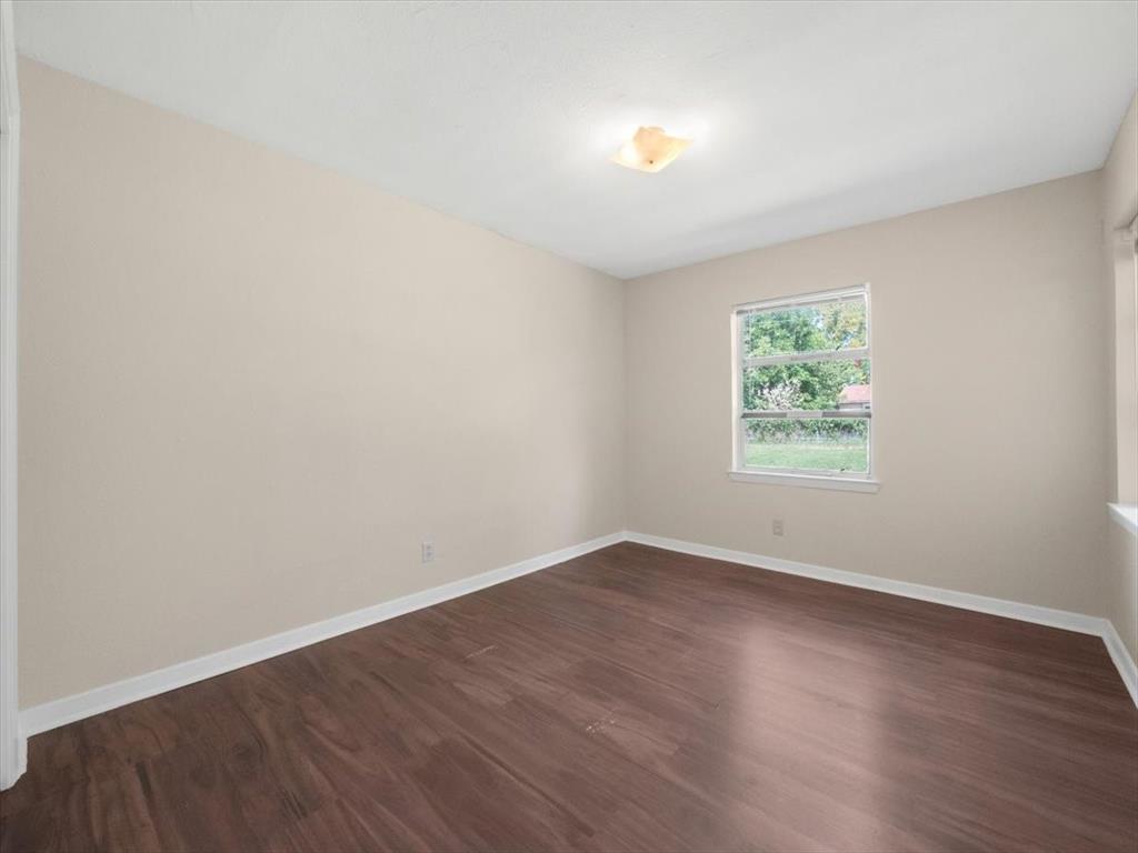 403 Rolando Drive Garland, TX 75040 - Photo 18 of 25 an empty room with wooden floor and windows